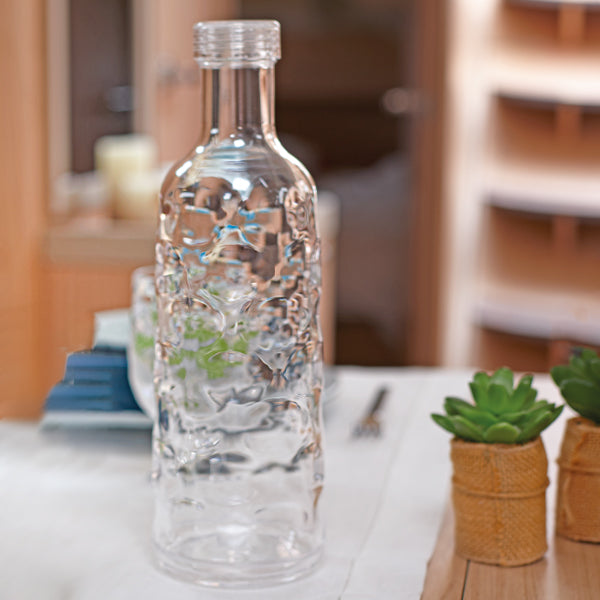 Marine Business karaffel med elegant design, set bagfra med vin og glas i forgrund.