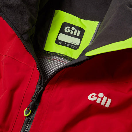 Person iført Gill jakke på båd under sejlads i klart vejr